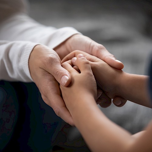 Close up of a woman's hands holding a young child's