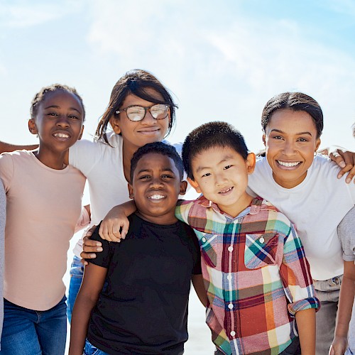 Gropu shot of smiling multi ethnic children with a woman