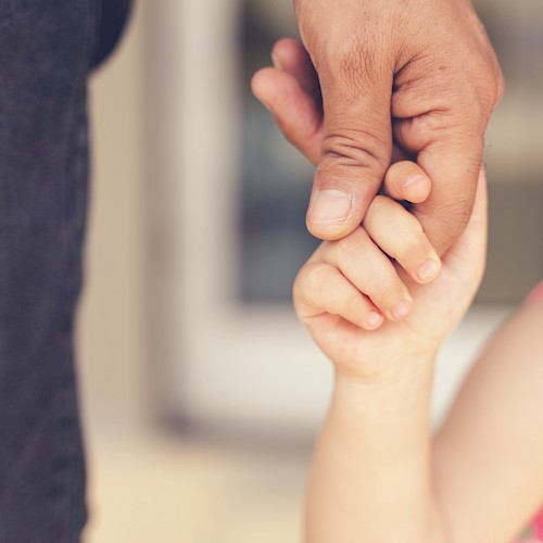 Very young child's hand holding that of an adult