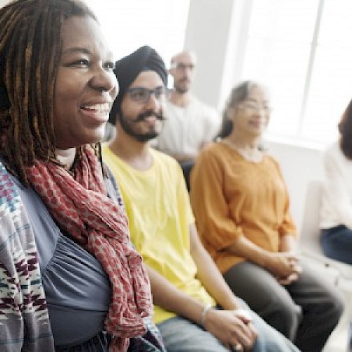 BAME woman smiling in a meeting group